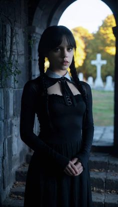 a woman wearing a black dress standing in an archway