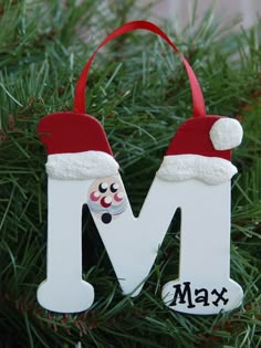 a close up of a christmas ornament on a tree with the letter m