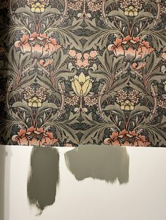 the wallpaper is being painted with brown and pink flowers on it's side