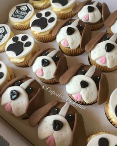 a box filled with cupcakes covered in frosting and decorated like dogs'faces