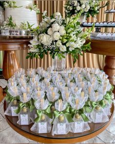 a table topped with lots of white flowers and small bags filled with chocolates next to each other