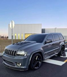 a gray jeep parked in front of a building