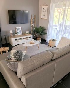 a living room filled with furniture and a flat screen tv on top of a wall