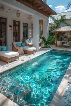 an outdoor swimming pool with lounge chairs around it