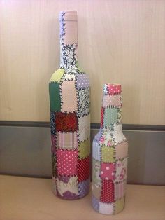 two wine bottles made out of patchwork fabric are sitting on a counter next to each other