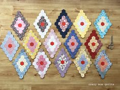 several pieces of quilted fabric laid out on a wooden surface