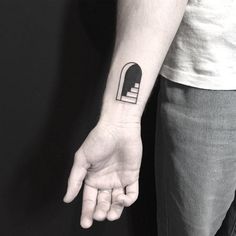 a person with a black and white tattoo on their left arm holding the hand of another person