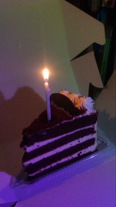 a slice of cake with two candles on it