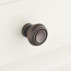 a close up of a knob on a white cabinet