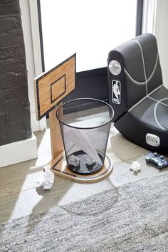 a trash can sitting on top of a floor next to a chair and other items