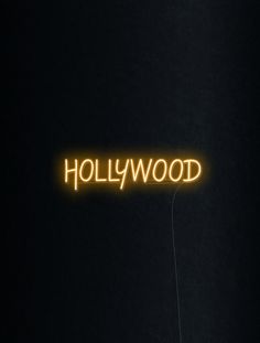 a neon sign that reads hollywood in the dark