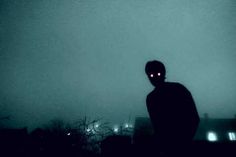 a man standing in the fog with his eyes glowing