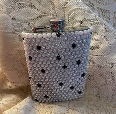 a white and black beaded purse sitting on top of a lace covered tablecloth