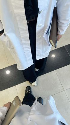 two people standing next to each other wearing white lab coats