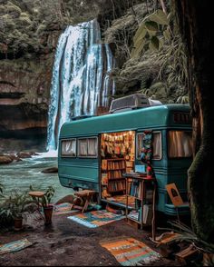 an rv parked in front of a waterfall with bookshelves on the floor and a book shelf