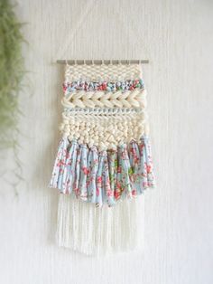 the wall hanging is decorated with flowers and fringes