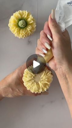 two hands holding different types of flowers on a table