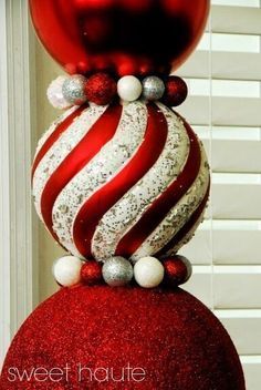 a red and white christmas ornament sitting on top of a red ball