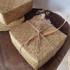 two wicker wrapped presents sitting on top of a wooden table