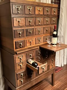 an old wooden cabinet with wine bottles and glasses in it on top of a hard wood floor