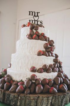 a wedding cake with chocolate strawberries on top