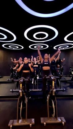 a group of people riding stationary bikes in a gym