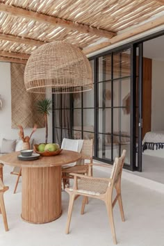 an outdoor dining area with wicker furniture and large sliding glass doors leading to the patio