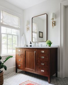 a bathroom with a sink, mirror and rug