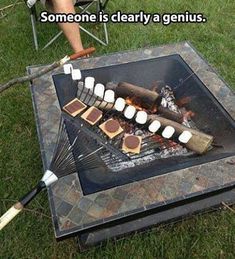 someone is clearly a genius cooking marshmallows over an open fire pit on the grass