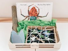 a box filled with lots of different types of toys and paper in front of a book