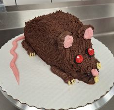 a cake shaped like a rat sitting on top of a white plate