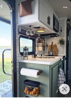 a kitchen area with a sink, stove and oven inside of a camper trailer