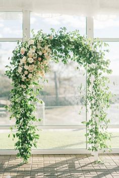 the wedding arch is decorated with white flowers and greenery for an outdoor ceremony or reception