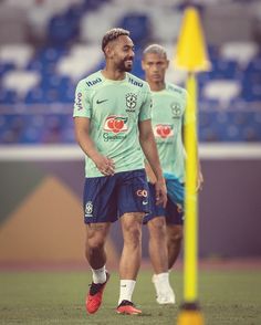 two soccer players are walking on the field