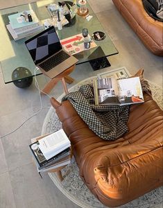 a living room filled with furniture and a glass coffee table on top of a rug