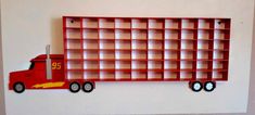 a red toy truck is sitting in front of a book shelf with numbers on it