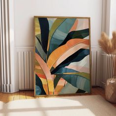 an abstract painting on the wall next to a vase with dry grass in it and a radiator