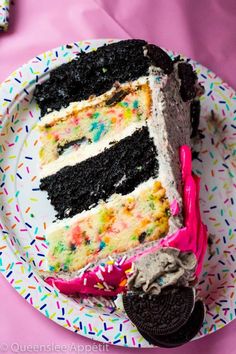 a slice of cake on a plate with sprinkles and an oreo cookie