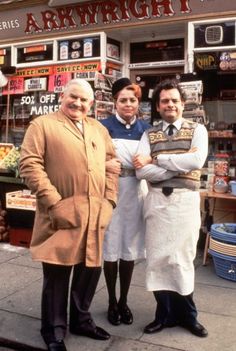 three people standing in front of a store