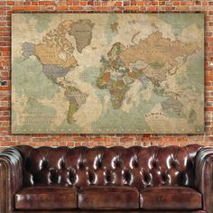 a brown leather couch sitting in front of a brick wall with a map on it