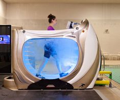 a woman is standing in front of an interactive swimming pool that looks like a toilet