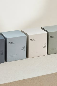 three boxes sitting on top of a counter in front of a white and gray wall