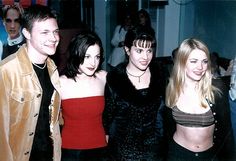 four people posing for the camera at a party