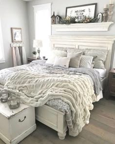 a white bed sitting in a bedroom on top of a hard wood floor next to a window