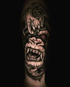 a man's arm with an evil face and red eyes on the upper half of his arm