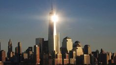 the sun shines brightly in front of a large city with tall buildings and skyscrapers