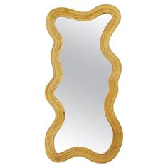 a gold framed mirror with curved edges and an ornate design on the bottom, against a white background