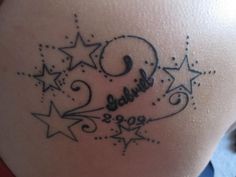 the back of a woman's stomach with stars and numbers tattooed on her belly