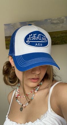 a woman wearing a blue and white hat with the word, west dutch on it