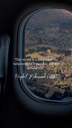 an airplane window with a view of a city and the words, this world is a prison for the believeers and a paradise for life